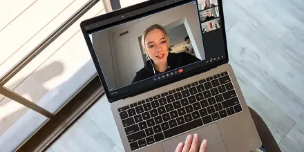 Woman on video call using laptop with dominant speaker detection highlighting active participant